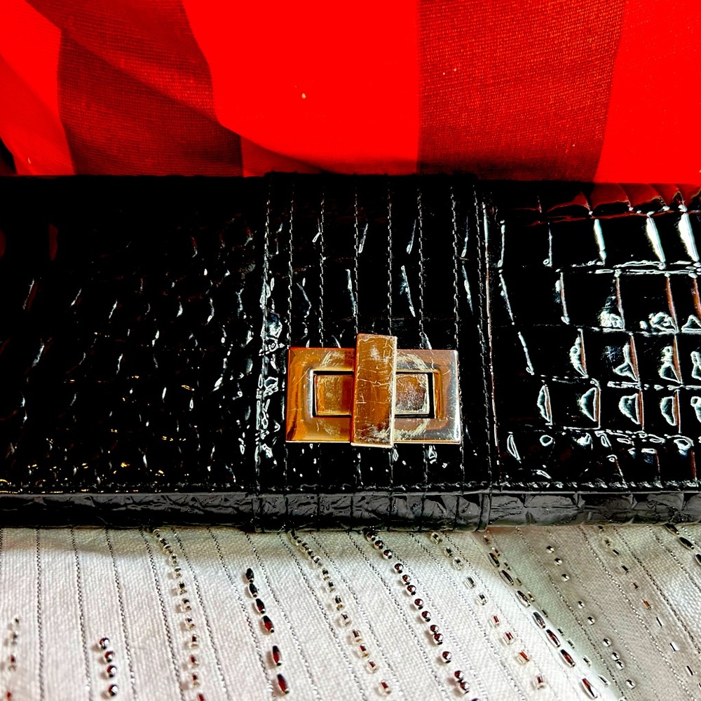 Simple black clutch bag with signs of wear on the silver hardware.